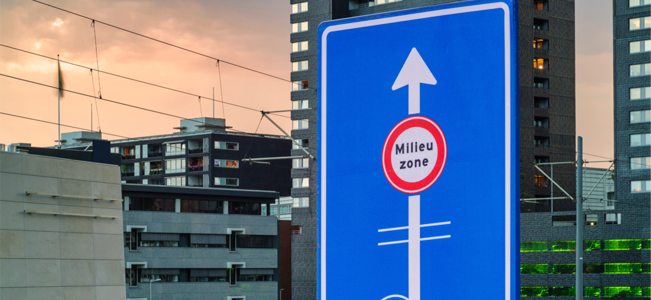 Bord van milieuzone met gebouwen in de achtergrond, 's avonds.