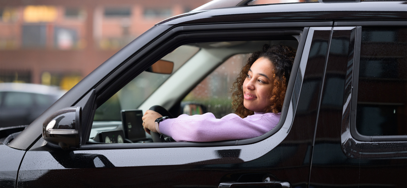 Vrouw rijdt in zwarte auto