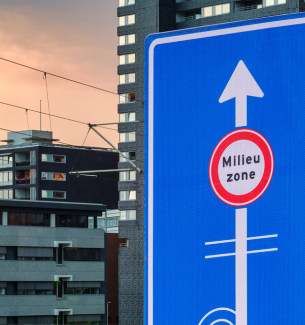 Bord van milieuzone met gebouwen in de achtergrond, 's avonds.