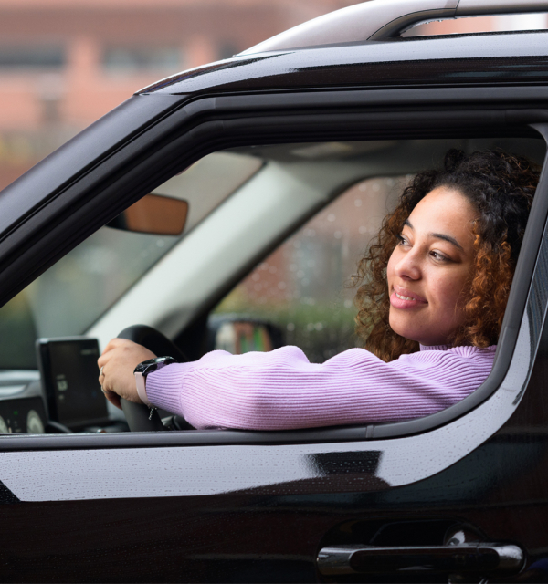 Vrouw rijdt in zwarte auto