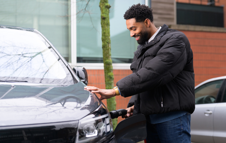 Man met laadstekker auto