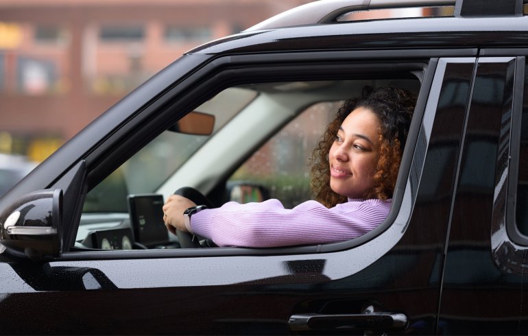 Vrouw rijdt in zwarte auto